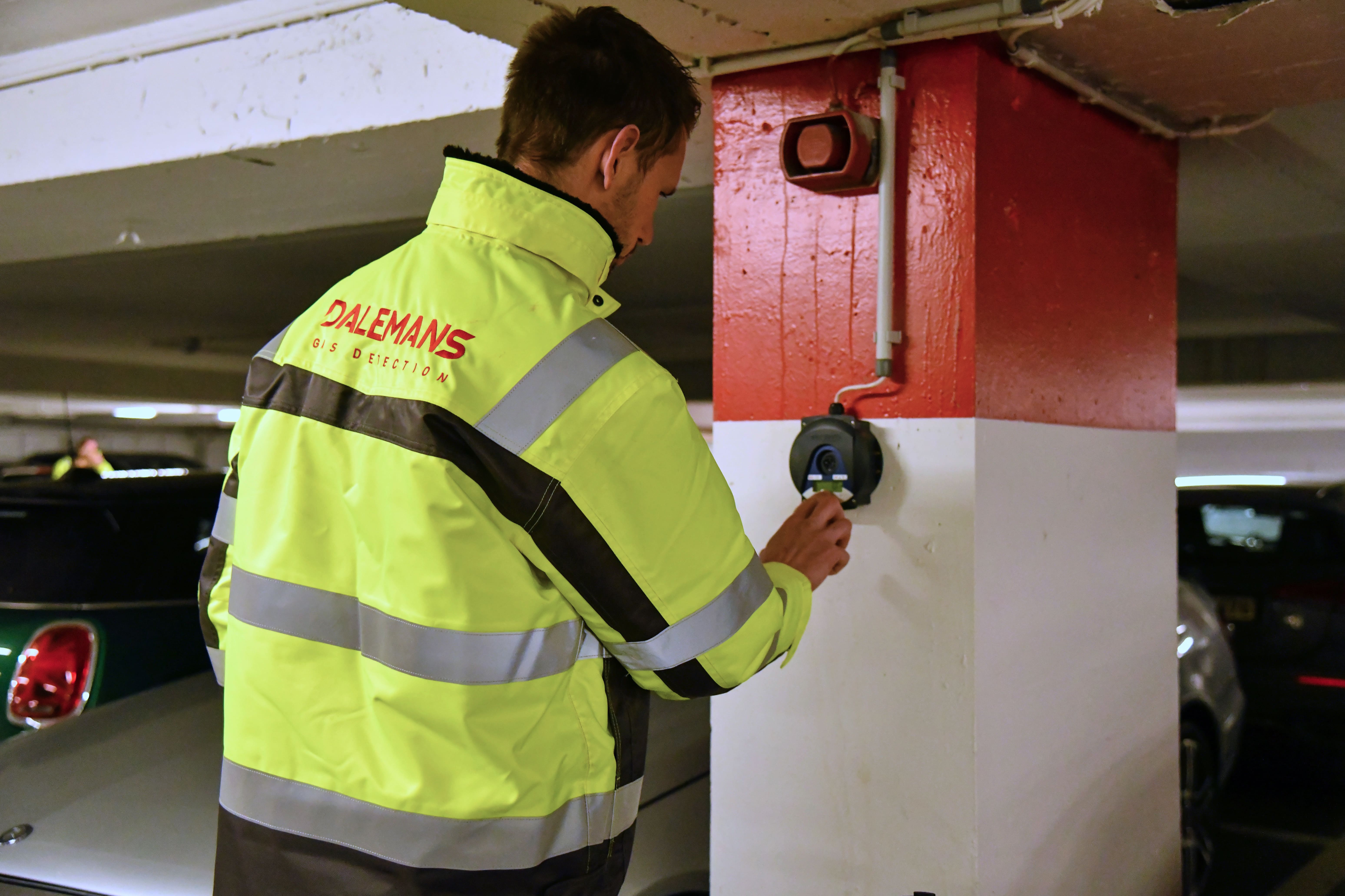 Technicien Dalemans effectuant une vérification de détection de gaz dans un parking souterrain